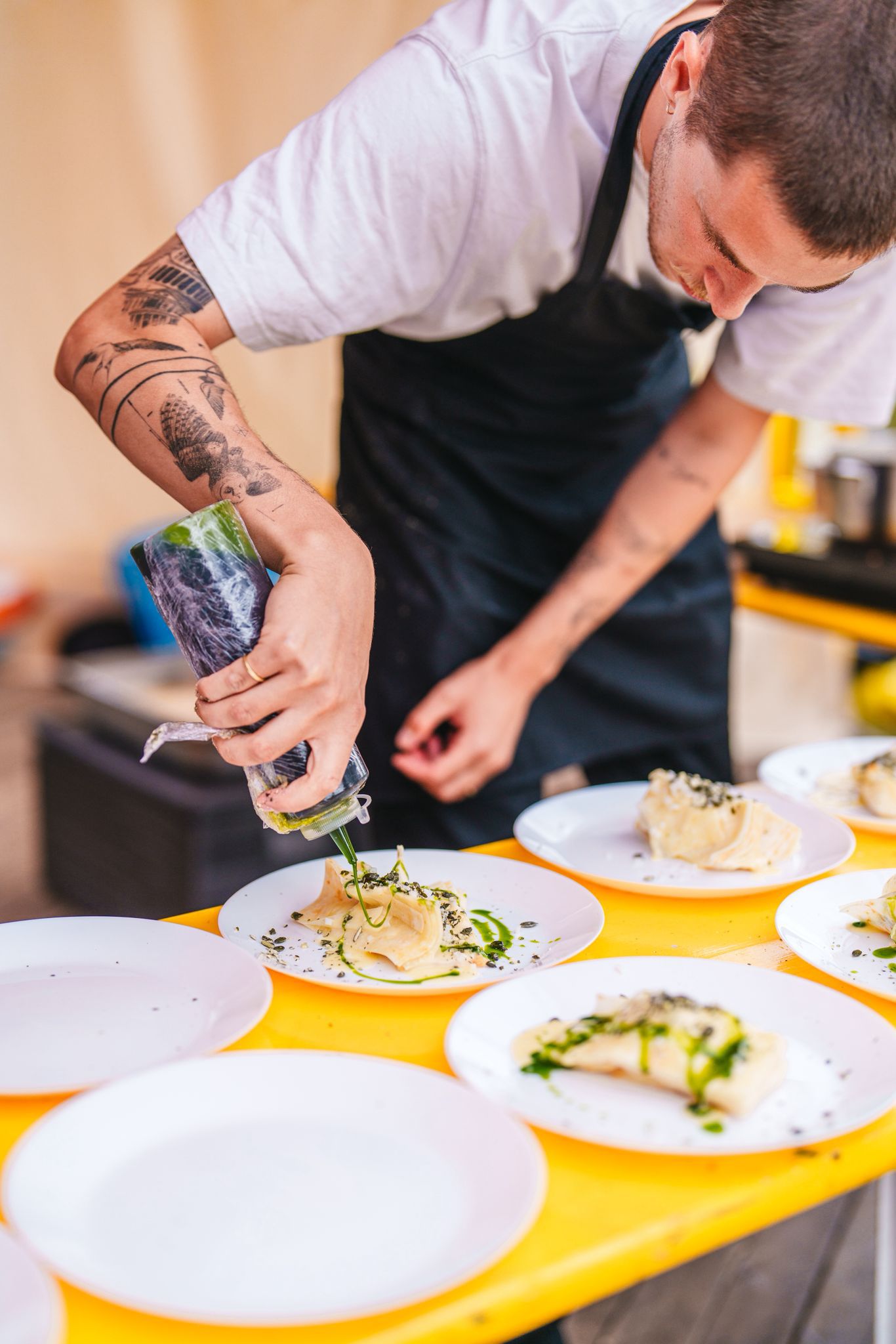 Chef schept saus over pasta op locatie