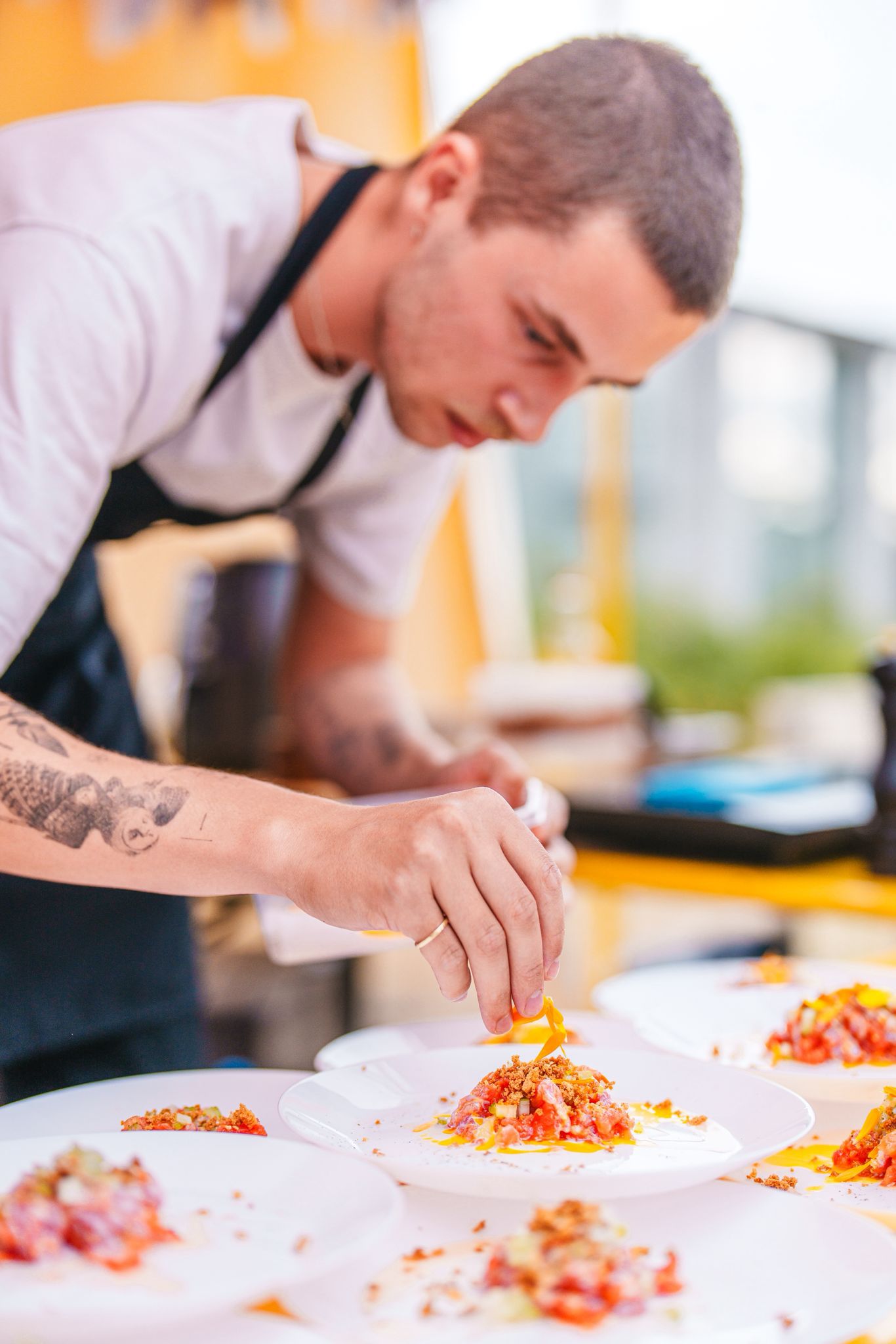 Twee chefs geven een gerecht uit aan een lange tafel
